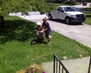 Ethan teaching Jake how to ride a two wheeler bike