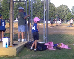 Anna 8 years old waiting to bat watching her softball game