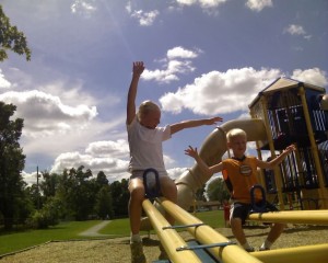Anna and Spencer on see saws at the park on a beautiful day.