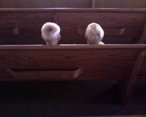 Spencer and Jake sitting in a pew at Church. 