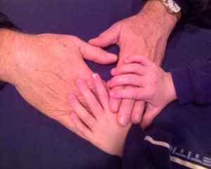 Jake holding Grandpa's hands