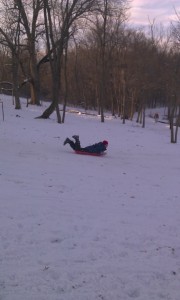 Ethan sledding down a steep hill