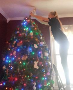 Anna placing the angel on the Christmas Tree