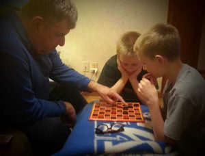 Dad and my son playing checkers